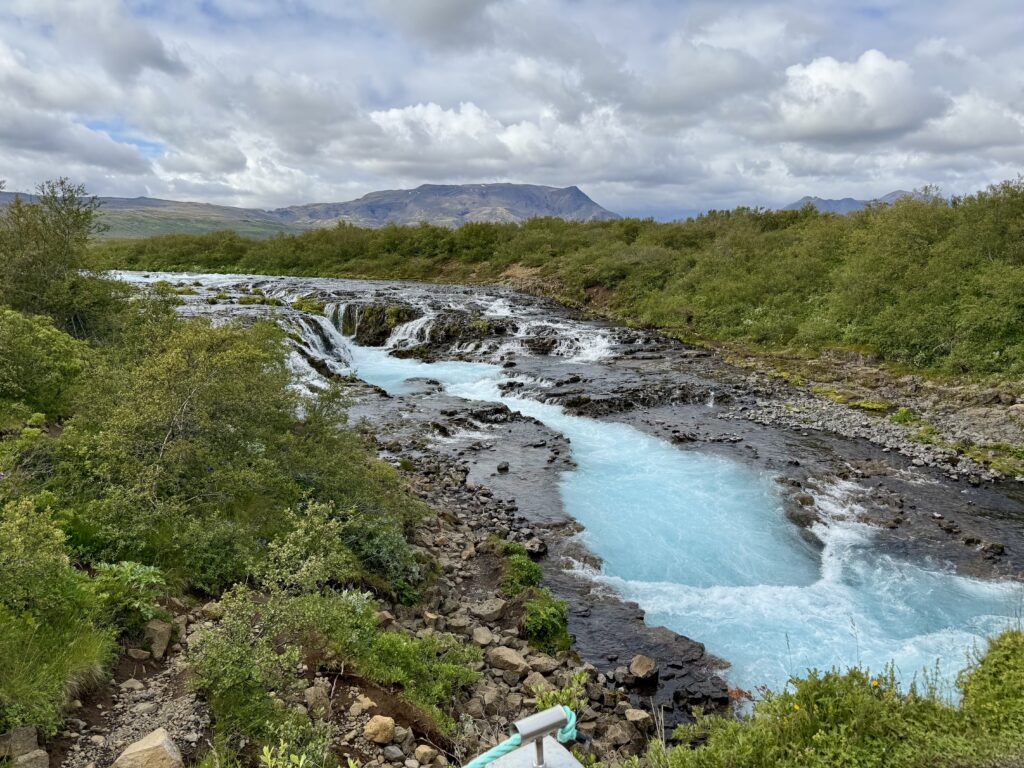 Waterfalls flowing through green hills in Iceland’s countryside