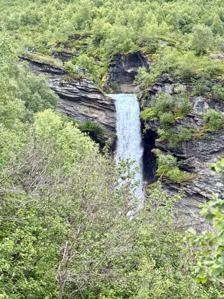 Hiking to Storsæterfossen waterfall near Geiranger, Norway fjord travel.
