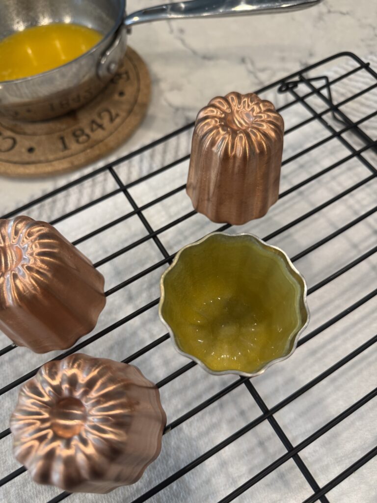 Preparing copper canelé molds with beeswax and butter